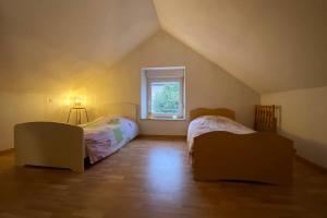 a attic room with two beds and a window at Gîte dû Raddon in Raddon-et-Chapendu