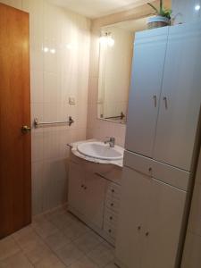 a bathroom with a sink and a white refrigerator at La Vista al mar de Belén in Port Saplaya