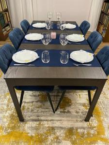 uma mesa com pratos e copos de vinho em Very Spacious & Modern 3Bed near Airport & Centre em Sófia