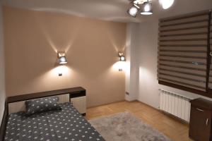 1 dormitorio con 1 cama y luces en la pared en Very Spacious & Modern 3Bed near Airport & Centre en Sofía