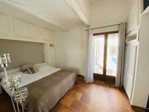 a bedroom with a bed and a large window at Le Patio Bleu in La Crau