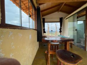 聖喬治的住宿－Chalé Beija Flor, venha viver essa experiência!!，客房设有桌椅和窗户。