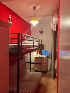 Casa Genny في نيتّونو: غرفة نوم بسريرين بطابقين وجدار احمر