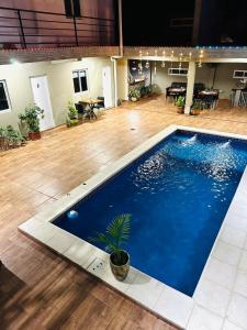 a large blue swimming pool in a room with a wooden floor at Departamentos El Chileno in Puerto Iguazú