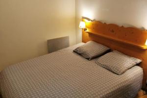 a bedroom with a bed with two pillows on it at Charmant T2 proche des pistes superbe vue in Chamrousse