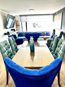 sala de estar con mesa y sillas azules en Hermoso departamento con jacuzzi privado, en Quito