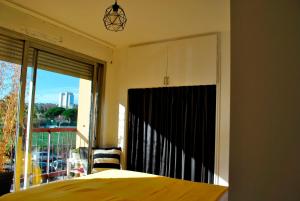 a bedroom with a bed and a large window at Confortable, lumineux et fonctionnel in Nice