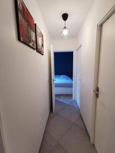 a hallway with a door to a bedroom with a bed at Appartement Noisiel 77 (proche Disneyland & Paris) in Noisiel