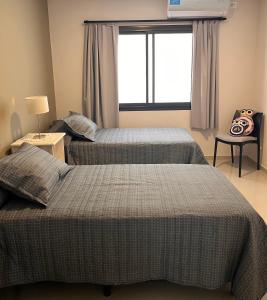 2 camas num quarto com uma janela em Depto Tatiana zona céntrica Carlos Paz em Villa Carlos Paz