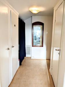 um corredor vazio com uma porta e uma janela em Central studio apartment em Gotemburgo