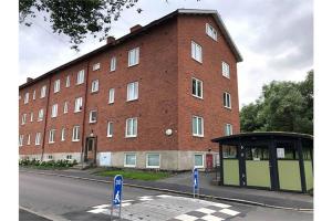 a large brick building with a bus stop in front of it at Central studio apartment in Gothenburg