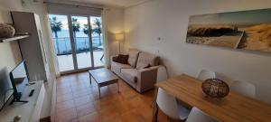 a living room with a table and a couch and a dining room at Apartamento en 1ª linea in Denia