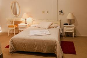 um quarto com uma cama com duas mesas e um espelho em Rigo Hotel em Santa Rosa
