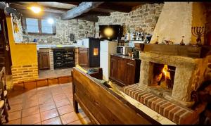 a kitchen with a large stone fireplace in a kitchen at Elpajardeportilla in León