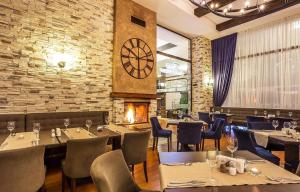 a restaurant with tables and chairs and a large clock at Apartaments by Zenit in Terra Complex B16 & C18 near Bansko in Razlog