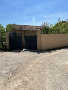 een huis met een hek en een garage bij Villa climatisé avec piscine et jacuzzi in Carpentras