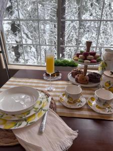 a table with plates and cups and a glass of orange juice at YoBee! Park Reservation Included! Heart of Yosemite - Homey Studios and Breakfast in Yosemite West