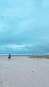 Ein paar Leute stehen am Strand in der Unterkunft Casa em Shangri-lá a 150m da avenida beira mar para até 10 pessoas in Pontal do Paraná