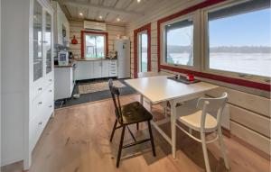 una cocina con mesa y sillas en una casa pequeña en Cozy Home In Hrryda With House Sea View en Härryda