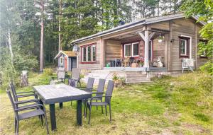 a table and chairs in front of a cabin at Cozy Home In Hrryda With House Sea View in Härryda