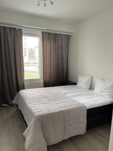 een slaapkamer met een groot wit bed en een raam bij Kaksio vuoreksessa in Tampere