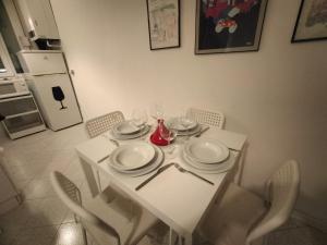 un tavolo bianco con piatti e bicchieri da vino sopra di Cavour Home a Trento