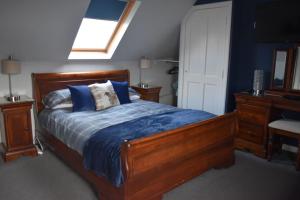 a bedroom with a bed with blue sheets and a window at Fort William loft on shore front with amazing views in Caol