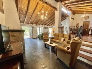 een woonkamer met banken en een flatscreen-tv bij La Alberguería complejo rural in Cañamero