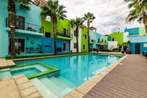 uma piscina em frente a um edifício com palmeiras em Cielomar em Tijuana
