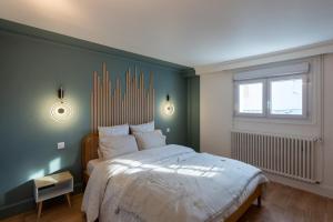 ein Schlafzimmer mit einem großen Bett und einem Fenster in der Unterkunft Au 9ème Art in La Rochefoucauld