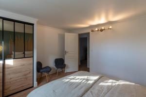 1 Schlafzimmer mit einem Bett und 2 Stühlen in der Unterkunft Au 9ème Art in La Rochefoucauld