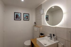 a white bathroom with a sink and a mirror at Au 9ème Art in La Rochefoucauld