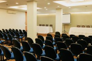 an empty room with chairs and a screen at Rigo Hotel in Santa Rosa