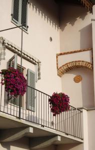 a balcony with geraniums on a building at Cà Veja in Montà