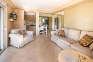 sala de estar con 2 sofás blancos y cocina en Beachside Bungalows, en Atenas