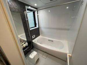 a small bathroom with a sink and a tub at Ms. White Beach Resort in Kanayama