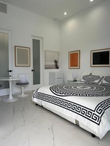 Men only clothing option guesthouse near Wilton Manors في فورت لاودردال: غرفة نوم بيضاء مع سرير كبير وطاولة