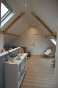 a living room with a vaulted ceiling with skylights at Vakantiehuis 't Hertenkamp in Ouddorp