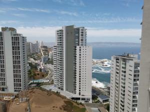 vistas a una ciudad con edificios altos y al océano en Exquisito Departamento Reñaca en el sector más turístico, en Viña del Mar