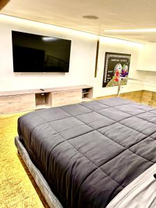 um quarto com uma cama grande e uma televisão de ecrã plano em Elegante loft con jacuzzi privado em Quito