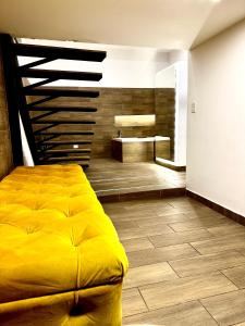 um quarto com uma cama amarela e uma casa de banho em Elegante loft con jacuzzi privado em Quito