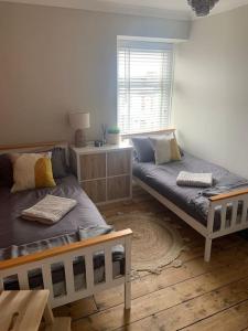 - une chambre avec 2 lits et une fenêtre dans l'établissement Quirky 3 Bedroom house with great views, à Pembrokeshire