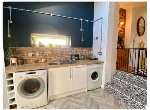 a laundry room with a sink and a washing machine at Quirky 3 Bedroom house with great views in Pembrokeshire