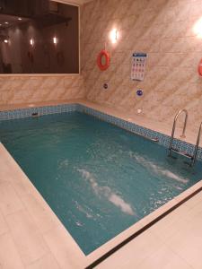 una grande piscina in una stanza con di سرايا ان شاليهات وغرف فندقية a Jazan