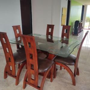 a glass dining table and chairs with a glass table and four chairs at Casa Mirador Alojamiento Campestre in Filandia