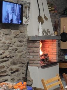 a stone wall with a fireplace with a tv at CASA RURAL PAJARICA en Sanabria in San Ciprián