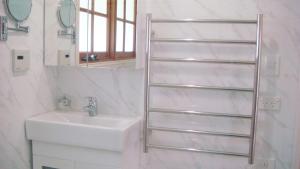un bagno bianco con lavandino e specchio di Tahara Cottage a Deloraine Altre 10 foto