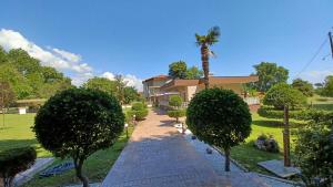 una casa con una palmera y una pasarela en My Rooms en Leptokarya