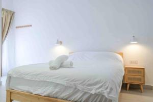 a bed with white sheets and a white towel on it at Comfy Sofy 23- Balcony Garden (Night market) in Tanah Rata