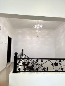 eine Treppe in einem weißen Zimmer mit einem Kronleuchter in der Unterkunft Homely.8 شقة in Firq